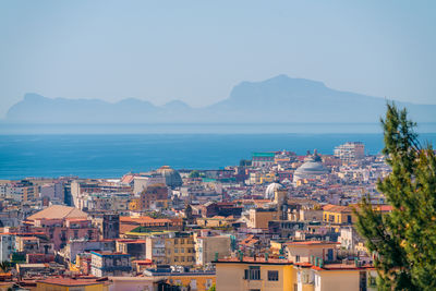 High angle view of townscape by sea against sky