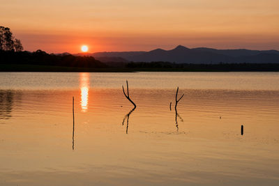 Scenic view of lake against orange sky