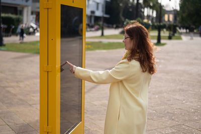 Side view of woman touching digital map at street