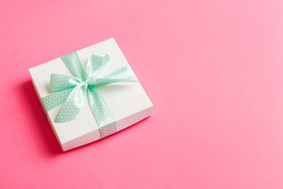 High angle view of gift box on pink background