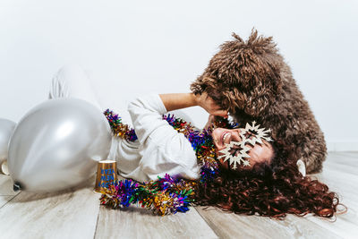 Woman lying on floor with dog against wall at home