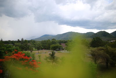 Scenic view of grassy landscape against cloudy sky