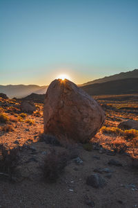 Rock formations on landscape against sky during sunset