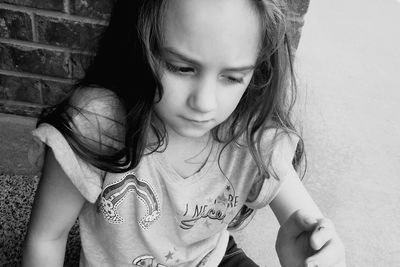 Cute girl looking away against wall