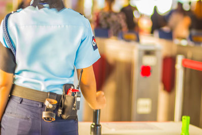 Midsection of female security guard standing at airport