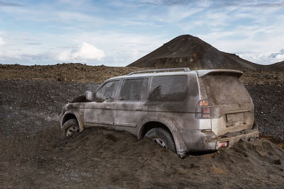 All terrain vehicle covered with dirt and volcanic sand after eruption against against fagradalsfjall in daytime in iceland