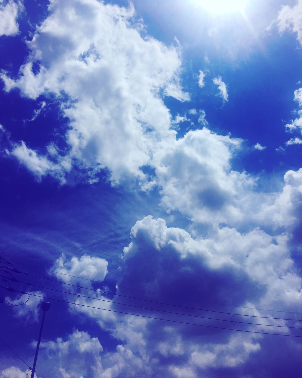 low angle view, sky, cloud - sky, beauty in nature, sky only, blue, scenics, tranquility, cloudscape, nature, tranquil scene, cloudy, weather, cloud, backgrounds, idyllic, majestic, day, no people, outdoors, sunbeam, white, full frame, sun, softness