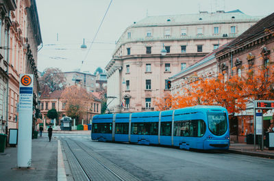 Train on city street and buildings