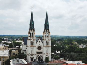 View of buildings in city against cloudy sky