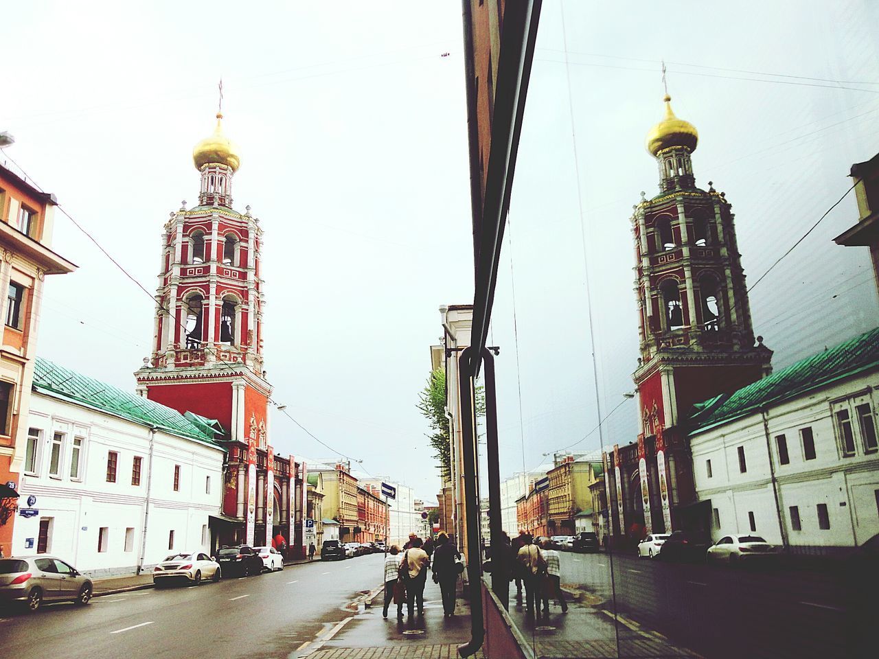 PEOPLE WALKING ON STREET AMIDST BUILDINGS IN CITY