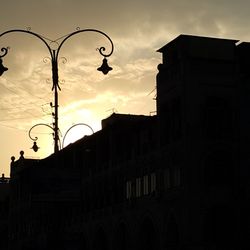 Low angle view of silhouette buildings against sky