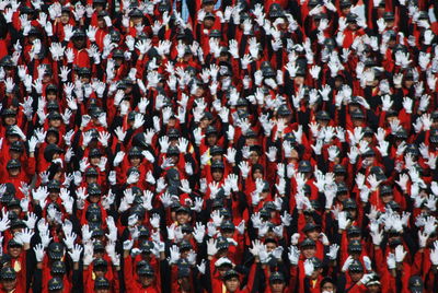 Full frame shot of people standing in uniform with arms raised during celebration