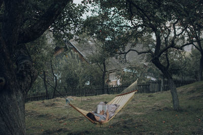 Woman relaxing in a hammock surrounded by trees