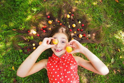 High angle view of girl holding apple on field