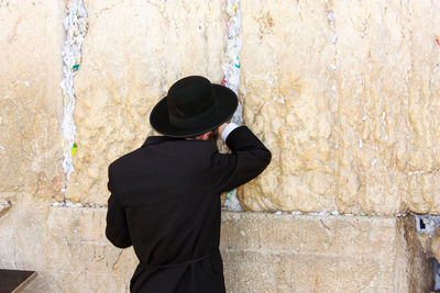 Rear view of man standing against wall