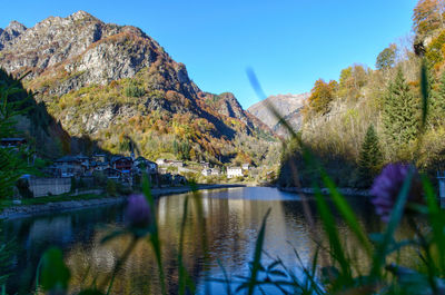 Scenic view of lake and mountains against clear sky
