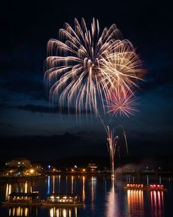 Firework display over river at night