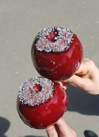 Cropped hands of friends holding taffy apple