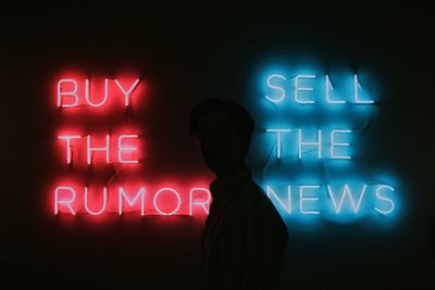 Close-up of woman standing by illuminated text