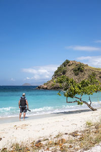 A photographer on pink beach in komodo national park, indonesia.