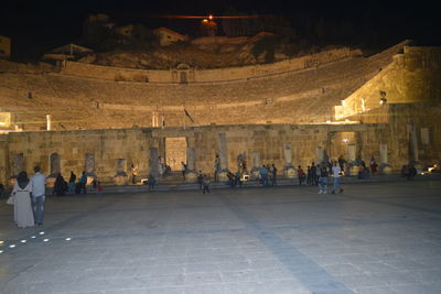 People at illuminated town square at night