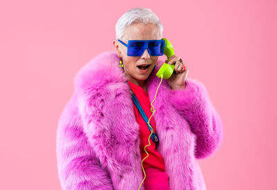 Portrait of young woman wearing mask against yellow background