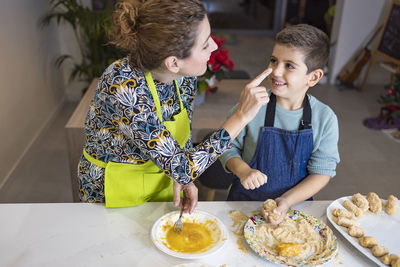 Mother and son making croquettes in the kitchen