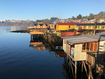 Panoramic view of buildings by lake against sky