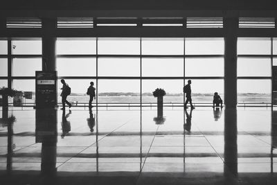 Silhouette people walking in airport lobby