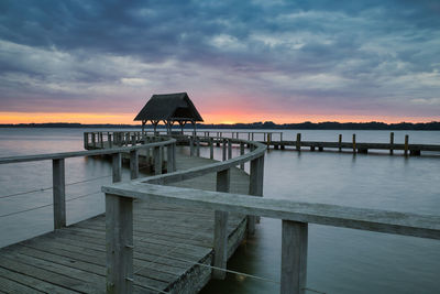 Pier over sea against sky during sunset