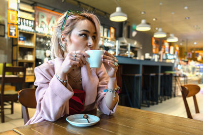 Young woman is drinking coffee in a cafe.