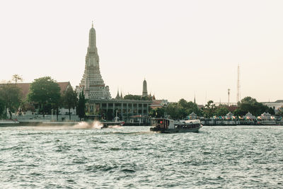 View of building by river against clear sky