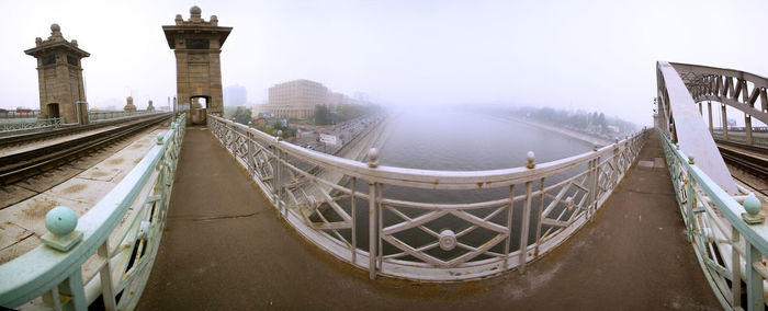 Krasnoluzhsky railway bridge over moscow river. city covered with smoke due to summer fires in 2010