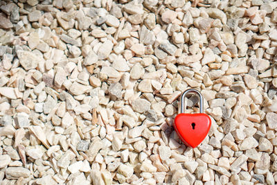 Close-up of heart shaped padlock on pebbles