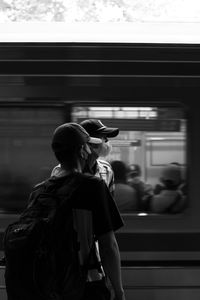 Side view of man standing in train