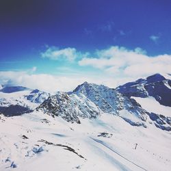 Scenic view of snow mountains against blue sky