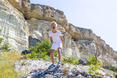 Portrait of smiling young woman on rock