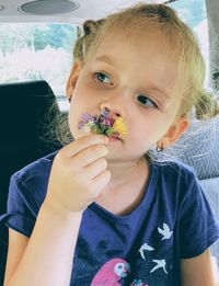 Close-up of girl smelling flower