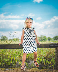 Full length portrait of girl standing against plants