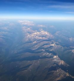 Aerial view of snowcapped mountains against sky