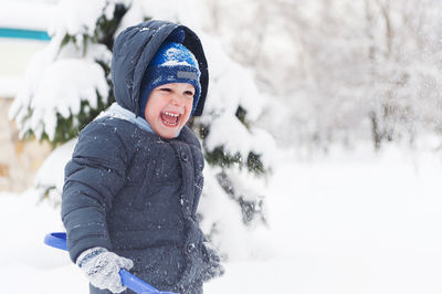 Full length of smiling boy in snow