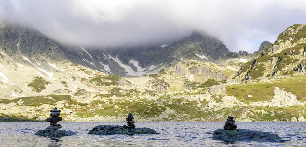 Scenic view of lake by mountains against sky