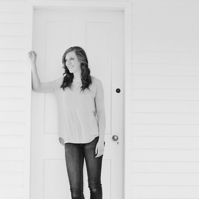 YOUNG WOMAN STANDING ON WALL