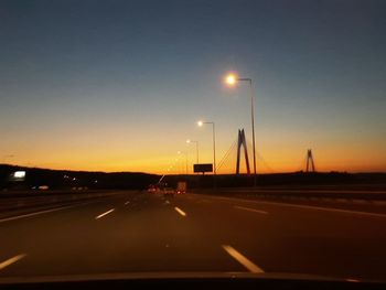 Cars on road against sky during sunset