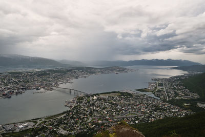 High angle view of city by sea against sky