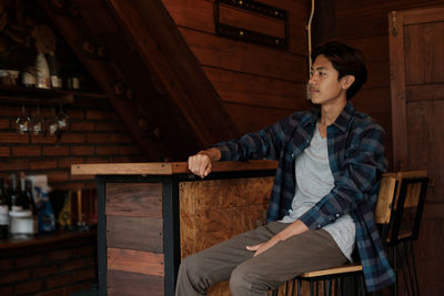 Portrait of young man sitting on chair