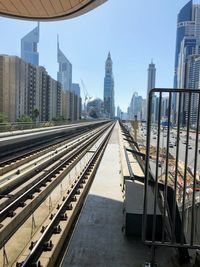 Railroad tracks in city against sky