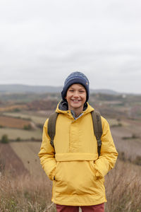 Portrait of smiling young woman standing on field