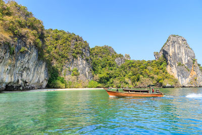 Long tail boat heading to lagoon bay at koh hong island, andaman sea at krabi, thailand