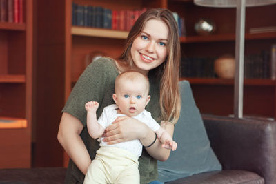 Portrait of a smiling young woman sitting at home